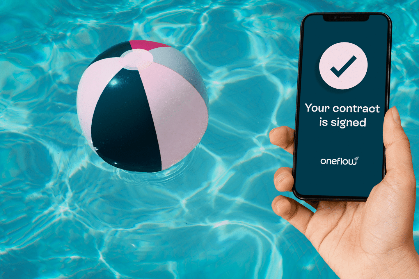 Hand holding phone with Oneflow contract in front of a pool and multicoloured beach ball – blog explaining how to write your signature on your phone 