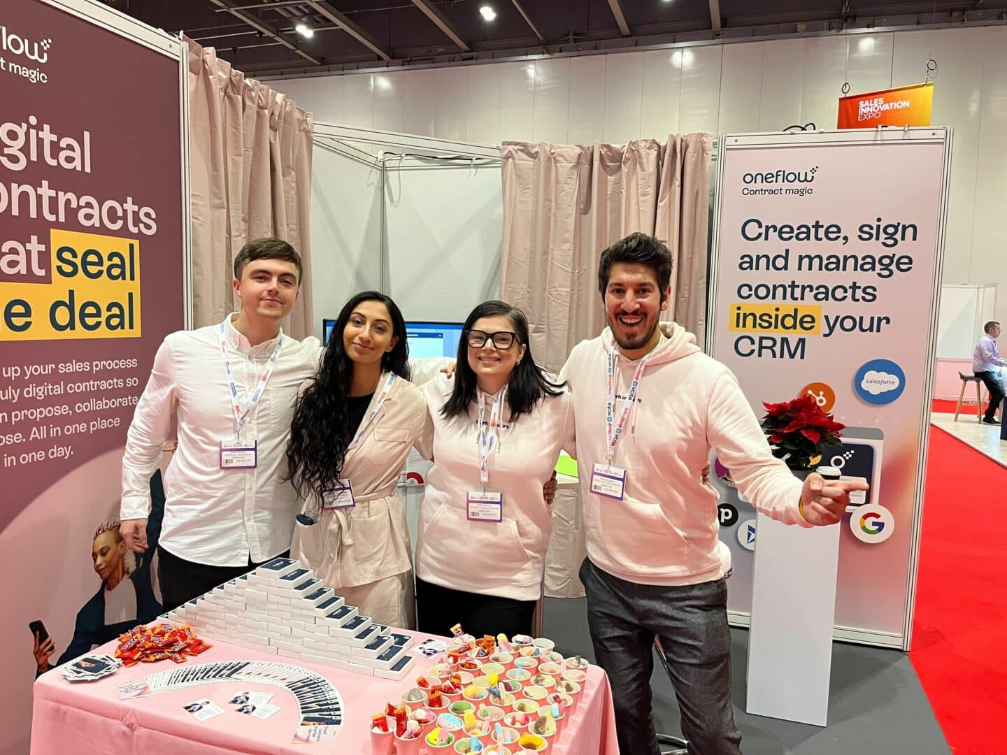 Team UK dressed in pink in front of the Oneflow stand at the Sales Innovation Expo in London