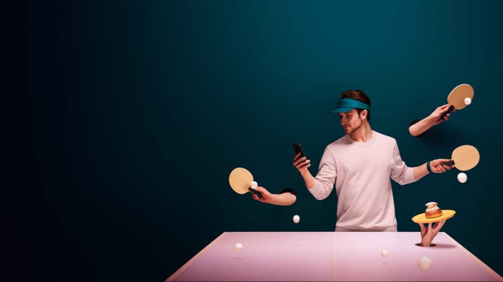Man wearing visor checking his phone while playing ping pong with multiple hands - blog on how to create a digital signature for car rental