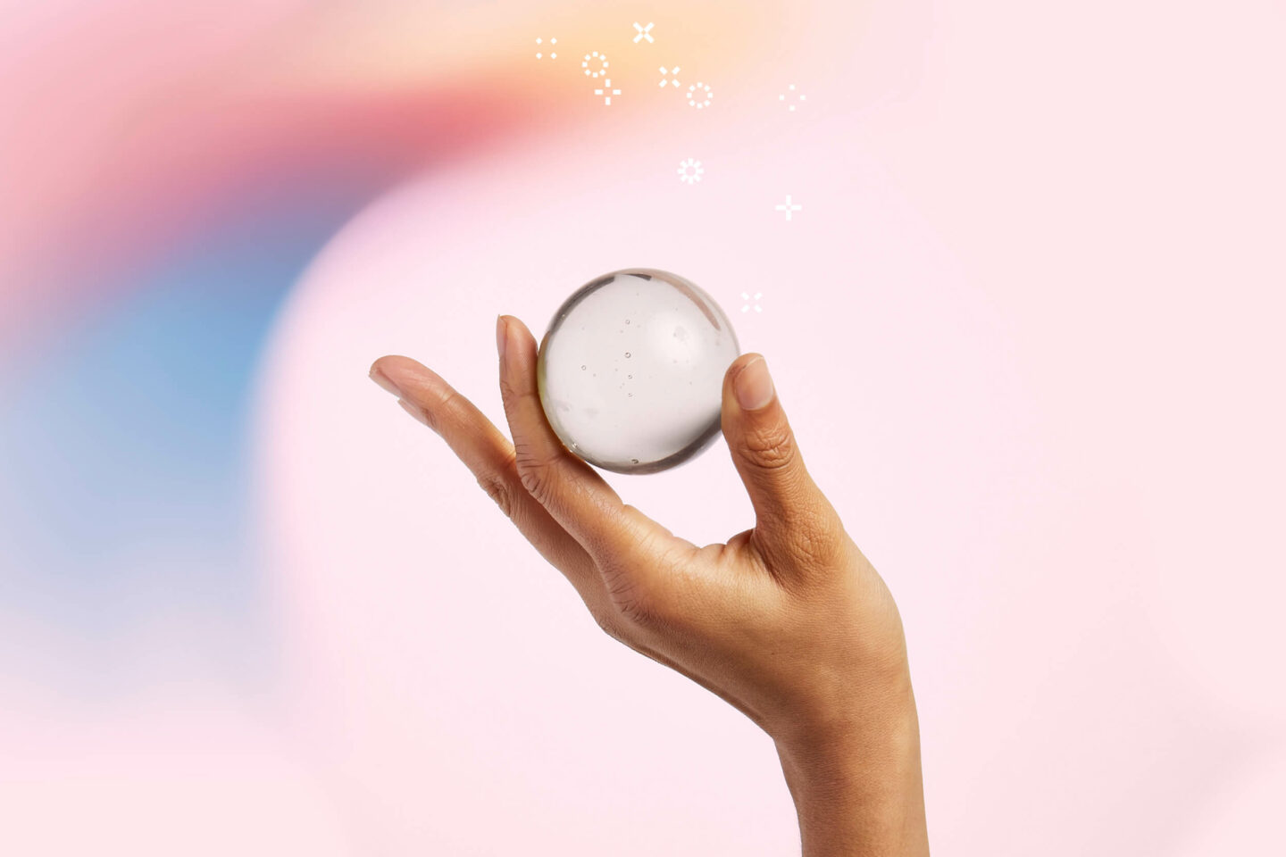 Hand holding a glass ball in front of pink background - blog on the importance of customer satisfaction